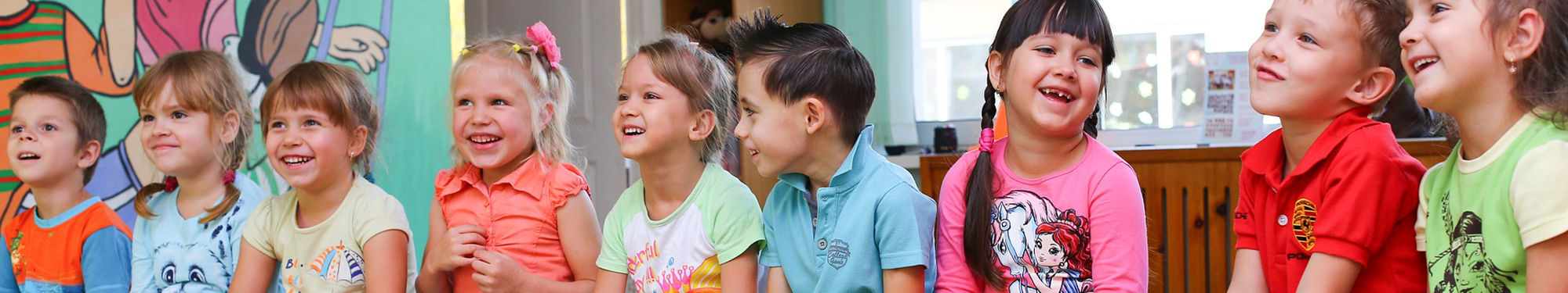 Fröhliche Kinder im Kindergarten auf einer Bank